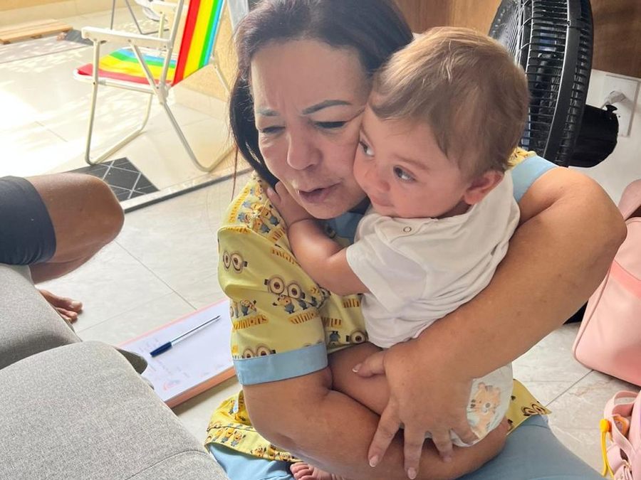 Dra. Sandra Barcellos com um bebê no colo durante a visita